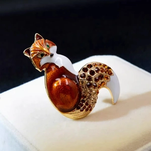 Close-up of elegant fox brooch with amber rhinestones and enamel on white jewelry box