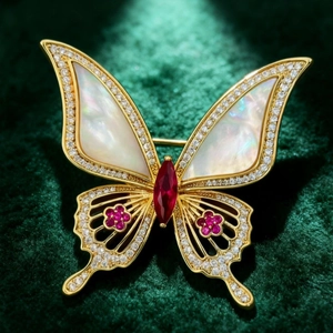 Élégante broche papillon en or avec nacre blanche et gemmes rouges sur velours vert