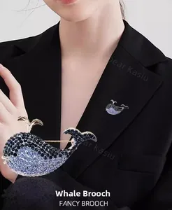 Detailed close-up of a blue whale brooch with sparkling rhinestones on a black suit lapel