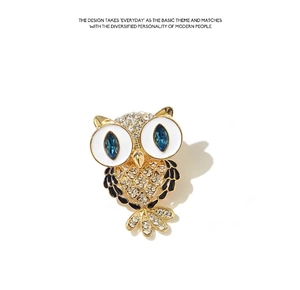 Detailed close-up of an owl brooch with blue gemstone eyes and sparkling white crystals