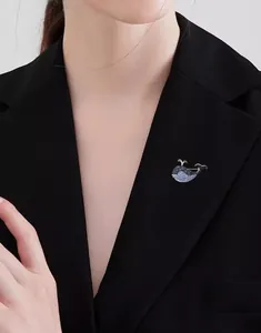 Detail of cute blue whale brooch with gradient rhinestones pinned on a black suit lapel