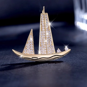 Exquise broche voilier dorée ornée de cristaux de zircon blancs scintillants