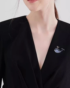 Detail of blue whale brooch with colorful rhinestones worn on a black suit jacket