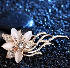 Détail d'une broche florale avec pétales d'opale et cristaux sur tiges en or rose
