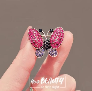 Exquisite butterfly brooch with purple rhinestones on a rose gold metal base