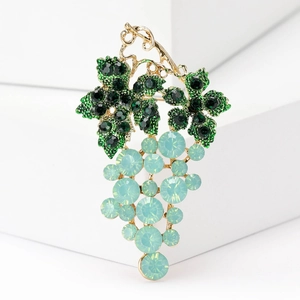 Macro shot of grape brooch with green crystal leaves and mint blue gemstone clusters