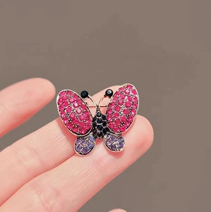 Elegant butterfly brooch with purple rhinestones on a gold base for suit lapels