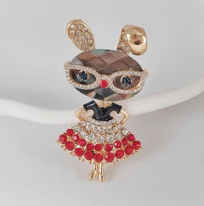 Détail de broche lapin avec tête en gemme gris fumé et accents de strass rouges sur la jupe