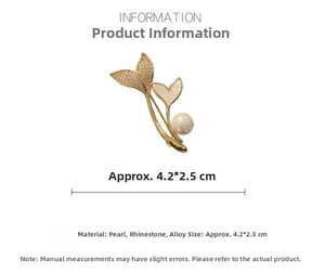 Detailed macro view of fishtail pearl brooch with gold alloy frame and crystal accents