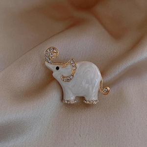 Close-up of elephant brooch with marble enamel and inlaid rhinestones on satin