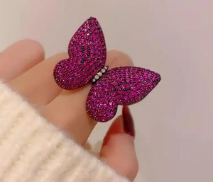 Macro view of luxurious butterfly brooch with vibrant rose pink zircon pavé setting