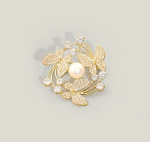 Macro detail of butterfly pearl brooch with sparkling crystals on gold metal plating