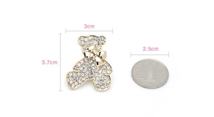 Comparaison détaillée de la taille d'une broche ours doré en strass avec une pièce