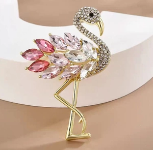 Dettaglio spilla fenicottero con cristalli rosa e diamanti su accessori geometrici