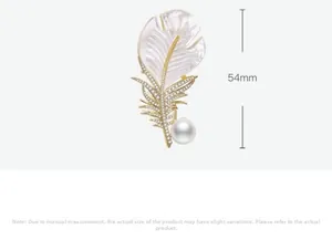 Vue détaillée d'une broche plume dorée avec nacre, perle et échelle de taille 54mm