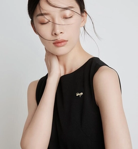 Broche abeille dorée épinglée sur une robe noire sans manches pour un style élégant