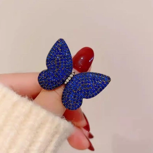 Luxury blue butterfly brooch with full crystals on hand for a vintage elegant look
