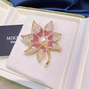 Broche feuille d'érable dorée avec cristaux roses et blancs et perle blanche au centre