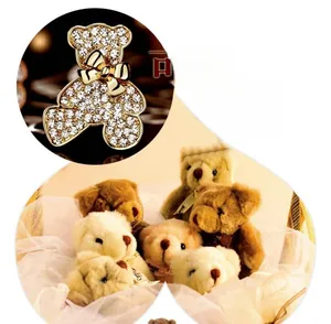 Détail d'une broche d'ours dorée avec strass scintillants et un petit nœud papillon