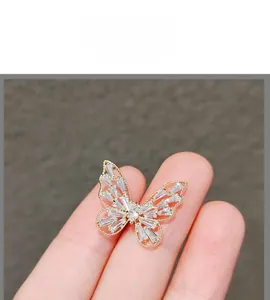 Gros plan sur la broche papillon dorée ornée de cristaux baguette et de détails raffinés