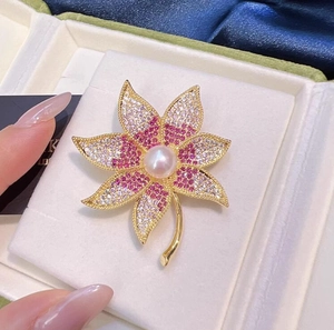 Gros plan sur la broche feuille d'érable aux cristaux colorés et perle centrale