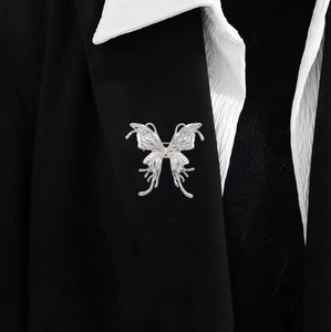 Silver liquid metal butterfly brooch with hollow design pinned on a black suit blazer
