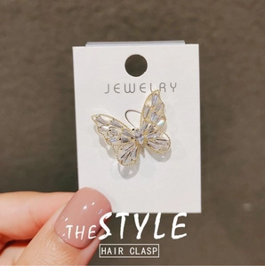 Barrette papillon dorée élégante avec ailes évidées et incrustation de zircone