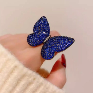 Luxury butterfly ring with deep blue crystals and silver body on hand view