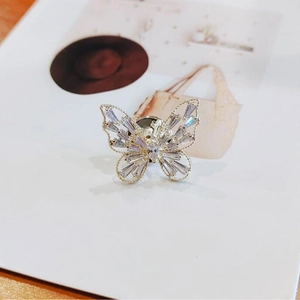Broche papillon élégante avec zircons cubiques brillants sur fond blanc minimaliste
