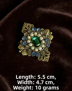 Dettaglio della spilla vintage dorata di 5,5cm x 4,7cm con smeraldo e perle fini