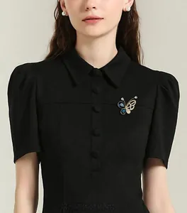 Détail d'une broche papillon évidée de luxe avec pierres bleues sur un manteau noir