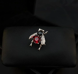 Macro shot of vintage bee brooch with red gemstone abdomen and crystal wings