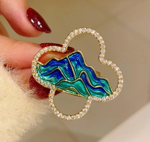Close-up of the exquisite landscape brooch with green enamel and sparkling rhinestones