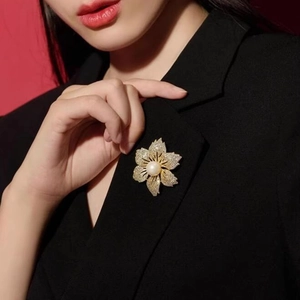 Elegante Blumenbrosche mit Kristallen und einer Perle auf einem schwarzen Anzugrevers