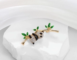 Macro detail of a panda brooch featuring sparkling rhinestones and green enamel bamboo