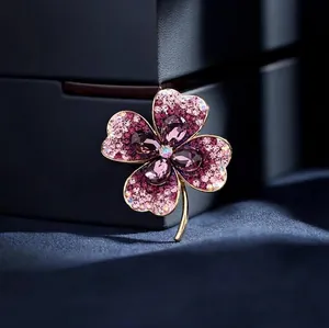 Élégante broche trèfle à quatre feuilles avec pierres violettes et diamants roses sur boîte