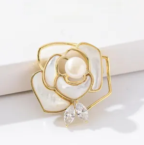 Detail of rose brooch featuring white mother of pearl petals and a central pearl accent