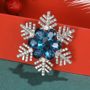 Close-up of snowflake brooch with blue teardrop crystals and white rhinestones decoration