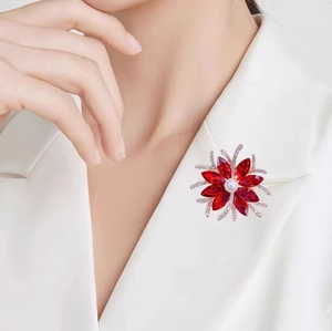 Elegant red crystal flower brooch with white pearl on a stylish white suit blazer