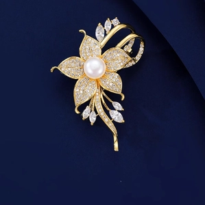 Eleganter goldener Blumen-Brosche mit weißer Perle und Kristallen auf blauem Grund