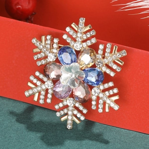 Golden snowflake brooch with colorful gemstones and white rhinestones on festive background