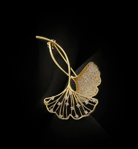 Makroaufnahme der luxuriösen Ginkgoblatt-Brosche in Gold mit funkelnden Kristallen verziert