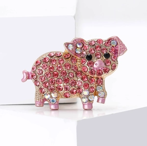 Detailed view of pig brooch with pink rhinestones and rose gold alloy finish
