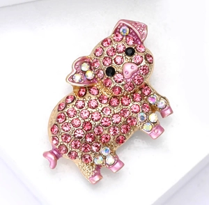 Detailed view of pink rhinestone pig brooch with gold base and enamel finish