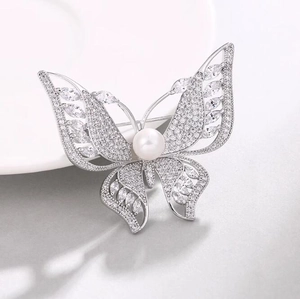 Broche papillon de luxe avec perle blanche et zircons scintillants sur métal argenté