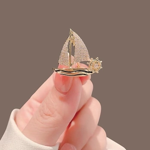 Elegant sailboat brooch with sparkling cubic zirconia pavé setting on golden alloy