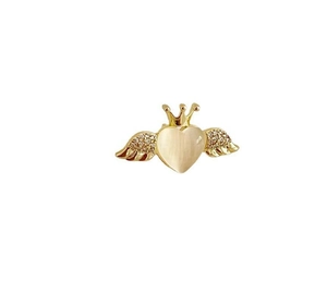 Macro shot of gold angel wings heart brooch with crown detailing and shimmering stones