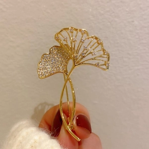Detail einer luxuriösen Ginkgoblatt-Brosche mit Goldbeschichtung und funkelndem Zirkon