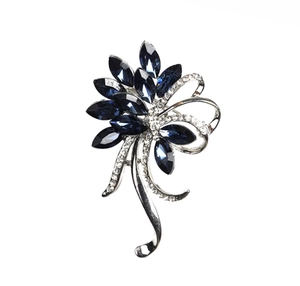 Détail de la broche bauhinia en cristal bleu avec ruban argenté et strass brillants