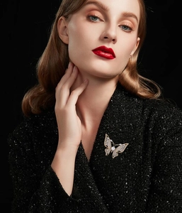 Vue détaillée d'une broche papillon en or de luxe avec perles et zircons sur manteau